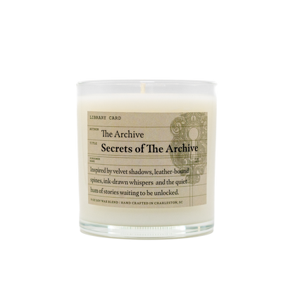 Candle with 'Secrets of The Archive' label on a white background