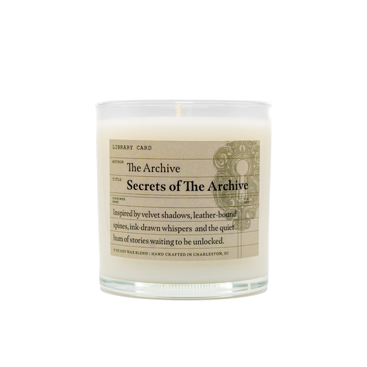 Candle with 'Secrets of The Archive' label on a white background