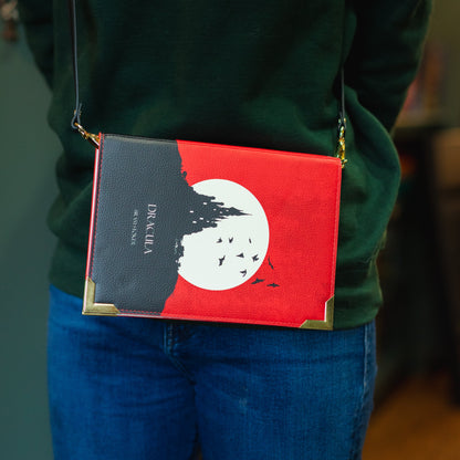 Person wearing a green sweater with 'The Archive' text, carrying a red and black crossbody bag.