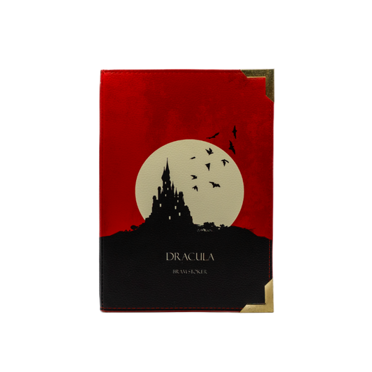 Book cover of 'Dracula' with a red background, moon, and castle silhouette.