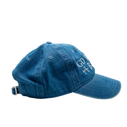 Blue denim cap with 'Go Abroad' text on a white background