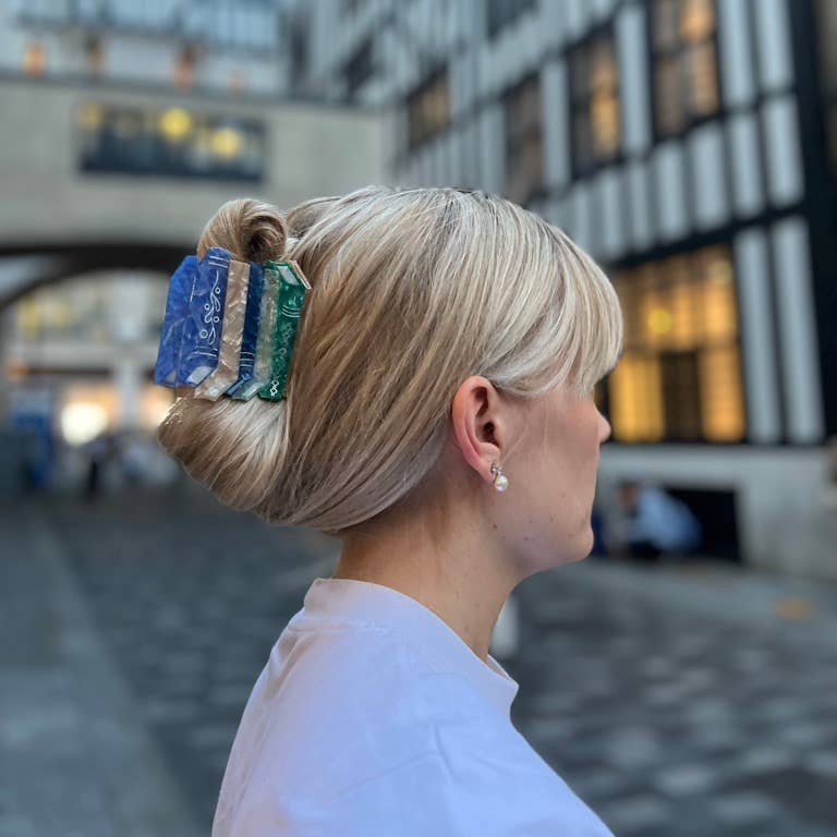 Person with a stylish haircut and hair accessory in an urban setting