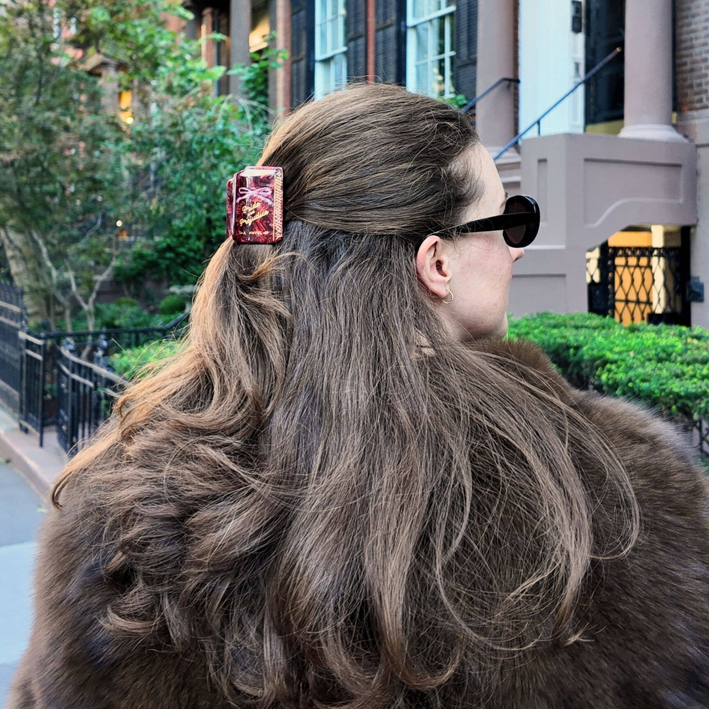 Person with long hair wearing a hair clip in an urban setting