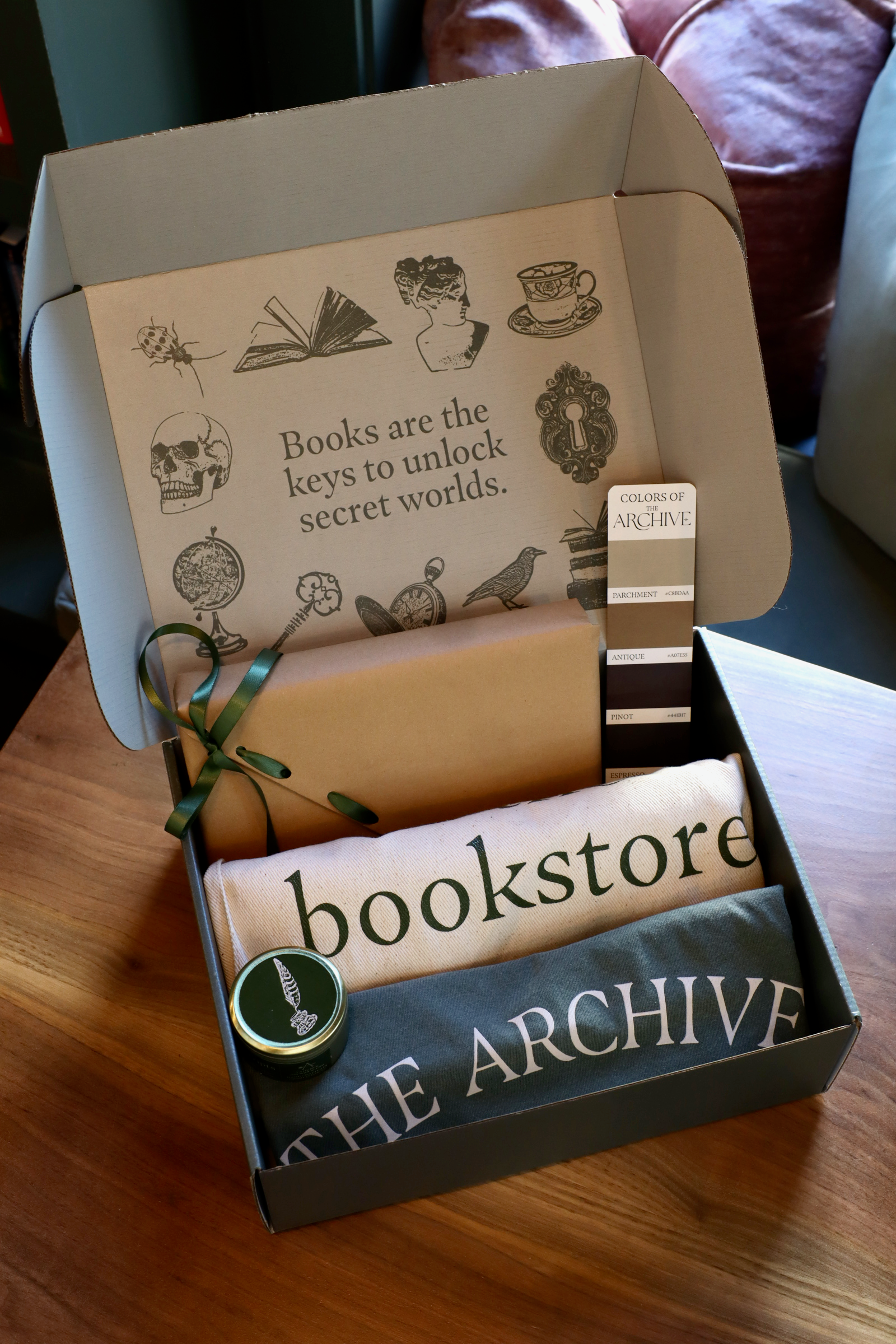 Essentials of The Archive Box with 'bookstore' and 'The Archive' items on a wooden surface