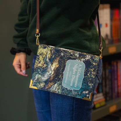Person wearing a crossbody bag with a nature-themed design in front of a bookshelf.