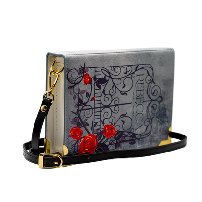 Handbag with floral design and gold accents on a white background