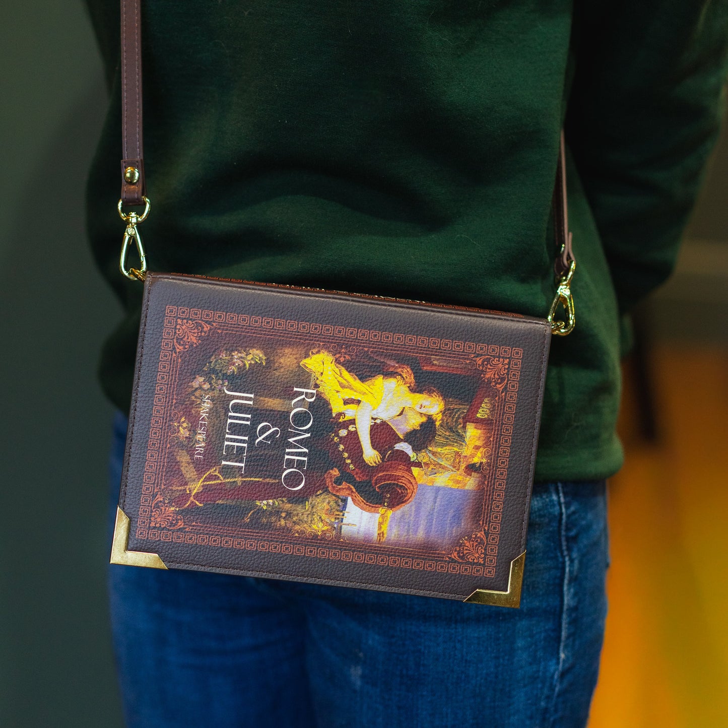 Person wearing a green sweatshirt with 'The Archive' text, carrying a book-themed crossbody bag.