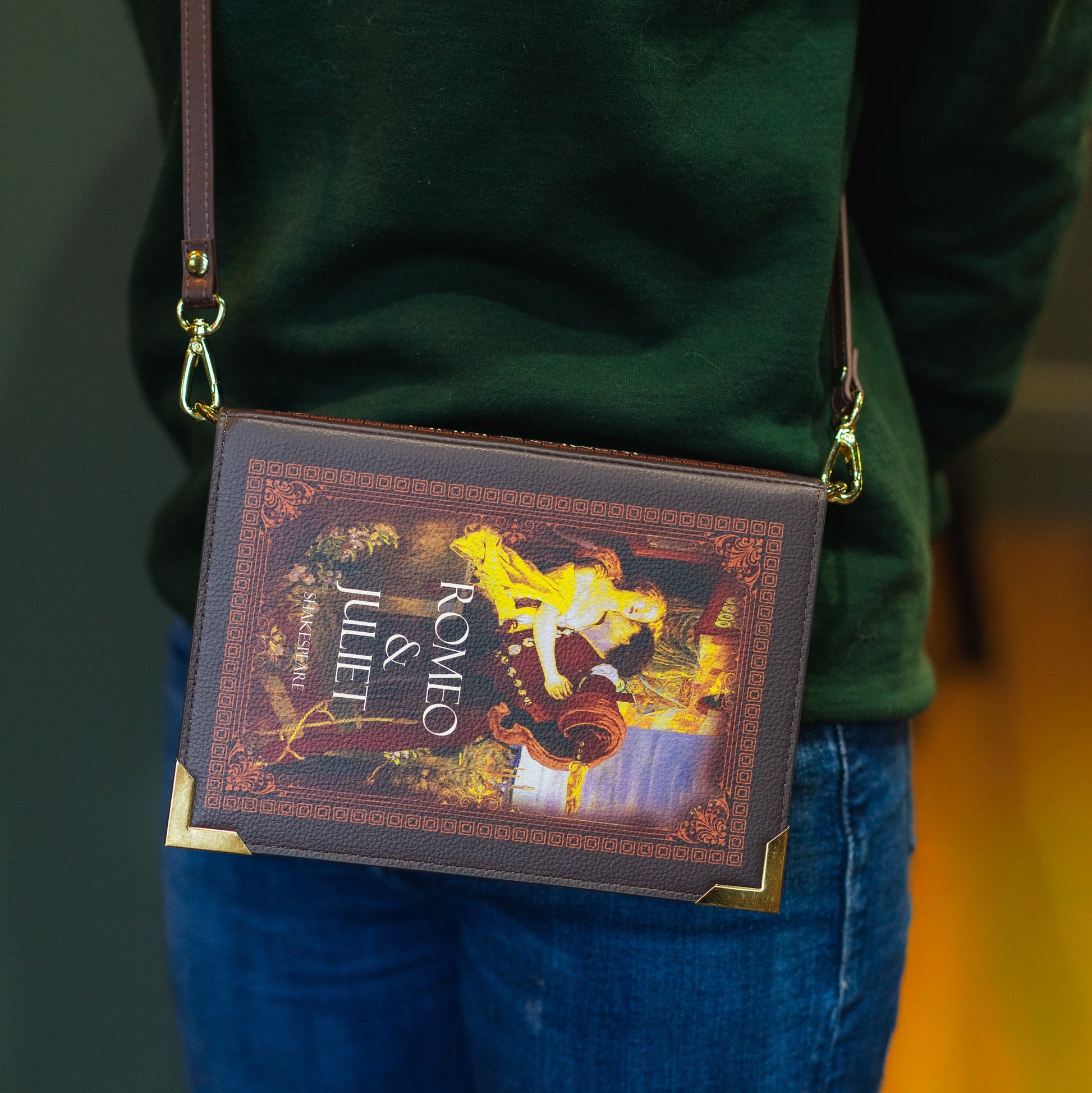 Person wearing a green sweatshirt with 'The Archive' text, carrying a book-themed crossbody bag.